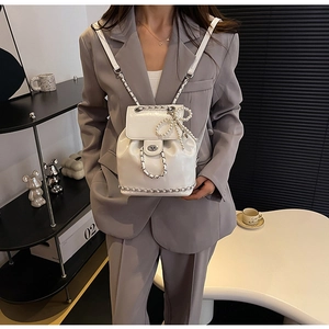 Elegante witte emmer rugzak met parelmoer strikdetail en stijlvolle kettingriemen