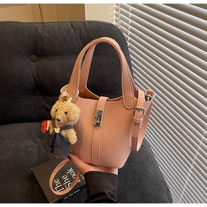 Pink lychee grain leather bucket bag with top handles and a cute bear plush pendant