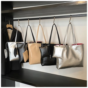 Detail view of large tote bags with red lining and matching pouches in three colors
