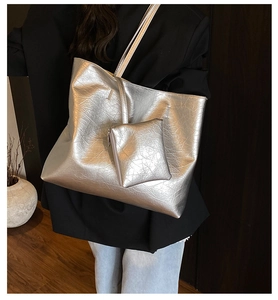 Silver large capacity tote bag with crinkle texture shown on model in a suit
