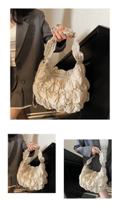 Close-up of pleated cloud bag details in beige with soft nylon texture and zipper