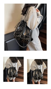 Detail of black wax leather drawstring backpack with silver rivets and metal chain straps