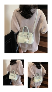 Detail of mint green mini handbag featuring metal buckle and heart charm attachment