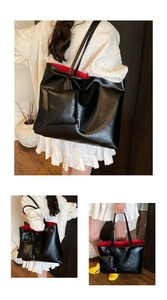 Macro shot of large black tote bag featuring contrasting red lining and magnetic clasp