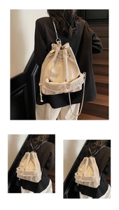 Detail of cream white drawstring bucket bag with silver studs and chain strap