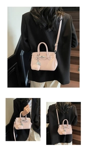 Detailed view of light pink mini handbag with metallic lock and heart charm accessory