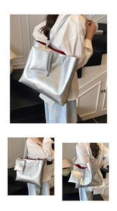 Detail of silver metallic tote bag with cracked texture and contrast red lining