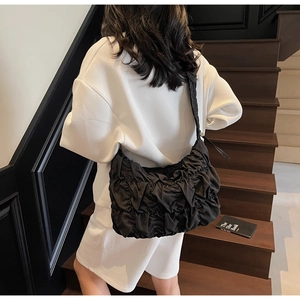 Detailed view of the black pleated cloud bag with textured fabric and spacious design