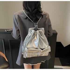 Detail view of silver drawstring bucket backpack with metal chain and rivet details