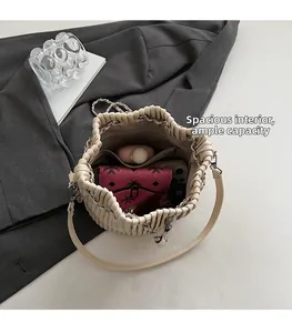 Top view of cream drawstring bucket bag showing spacious interior with metal chain