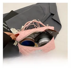 Detail showing inner capacity of pink quilted bag with silver chain and rotary lock