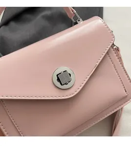 Gros plan d'un sac à main en cuir ciré rose clair avec fermoir rotatif argenté