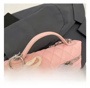 Detail of pink quilted leather vanity bag with pearl accents and silver chain strap