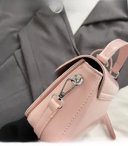Détail du sac en cuir rose montrant le fermoir en métal argenté brillant et les coutures