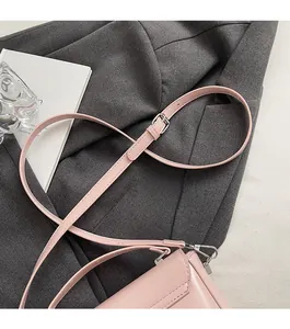 Détail de la bandoulière en cuir ciré rose avec boucle argentée sur un sac porté croisé