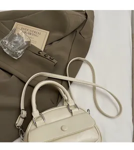 Detail of elegant beige leather handbag with smooth long shoulder strap and top handles