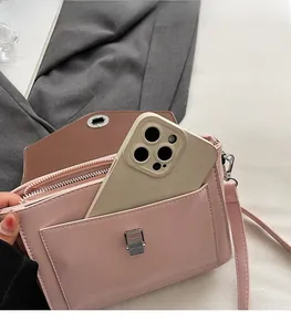Sac bandoulière en cuir ciré rose avec poche avant montrant la capacité du téléphone