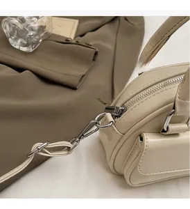 Detail of creamy white pillow bag featuring silver zipper and side flap pocket closeup