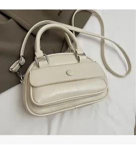 Close-up of cream handbag showing soft textured fabric and front flap pocket detail
