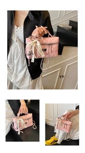 Detail of pink quilted handbag featuring elegant lace bow, pearls, and metal chain strap