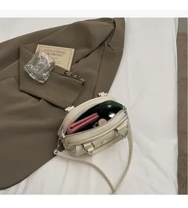 Macro shot of spacious inner compartment of cream shell bag with daily essentials