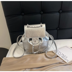 Detailed macro view of silver metallic mini backpack with chain and metal clasp closure