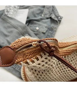 Macro shot of smooth metal zipper and brown leather trim on woven summer beach bag