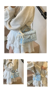 Close-up of light blue quilted crossbody bag with delicate lace and pearl tassel detail