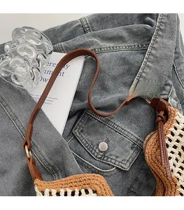 Detail of bohemian crochet woven bag with brown leather shoulder strap and fine craftsmanship