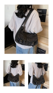 Detail of vintage washed denim biker bag with dual front pockets and metal buckle hardware