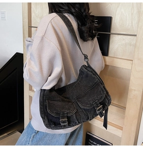Side view of black washed denim motorcycle bag with multi-pockets on casual model