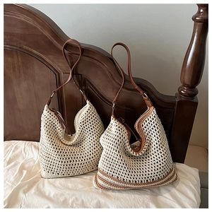 Detail of crochet hobo bags with leather straps hanging against a wooden background