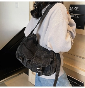 Detail showing vintage washed denim texture and functional pockets of the shoulder bag