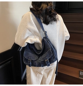 Detailed back view of a dark blue washed denim tote bag with functional flap pockets