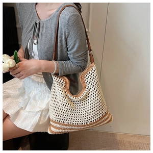 Detail of hand-woven off-white tote bag with brown stripes and leather shoulder strap