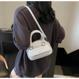 Detail shot of light blue glossy mini Boston bag with silver hardware and shoulder strap