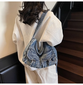 Detail view of retro washed denim hobo bag featuring dual front flap pockets and buckles