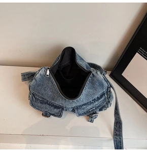 Detail view of denim motorcycle bag showing interior lining and front buckle pockets
