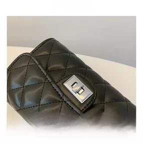 Gros plan du sac bandoulière matelassé noir avec fermoir rotatif en métal argenté