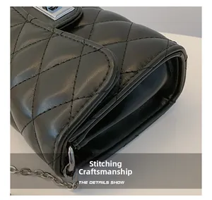 Détail du sac en cuir noir à losanges avec boucle argentée et bandoulière en chaîne