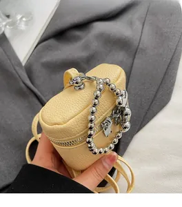 Detail of yellow lychee pattern mini bucket bag with silver ball chain handle