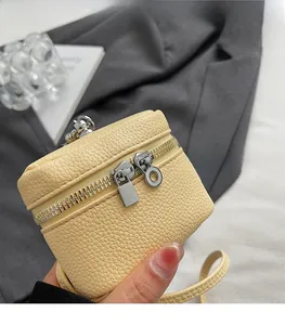 Detail showing smooth silver double zipper on yellow litchi grain mini shoulder bag