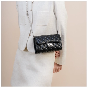 Détail du sac matelassé noir avec bandoulière en perles et fermoir rotatif en métal