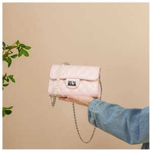 Détail du sac à bandoulière rose matelassé avec lanière en perles et chaîne