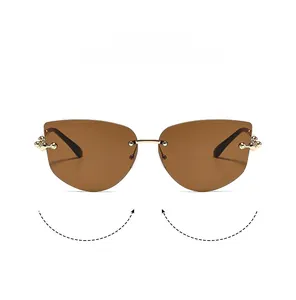 Détail de lunettes de soleil œil-de-chat sans monture avec verres bruns et métal doré