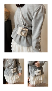 Detail of white pebbled leather bucket bag with silver heart charms and chain handle