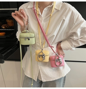 Close-up of mini crossbody bags in pastel colors with metal bead handles and leather straps