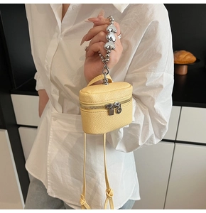Detail of yellow mini bag with litchi texture leather and silver heart bead handle