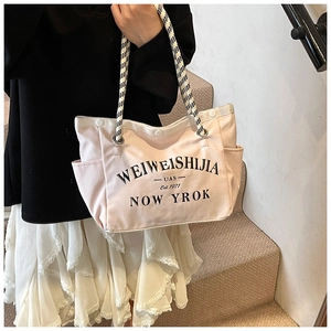 Détail du cabas en toile rose clair avec imprimé lettres noires et poignées en corde