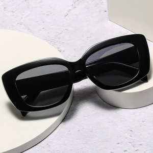 Modern square black sunglasses for women with thick resin frames on geometric props